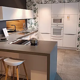 Moderne weiße U-Küche mit Sitzgelegenheit und Miele Geräten