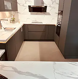 Moderne grifflose Küche in Mineralgrün mit Tisch