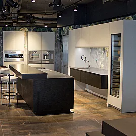 Edelstahl-Küche mit Möbeln in hellgrau-matt und Wave-Optik in schwarz