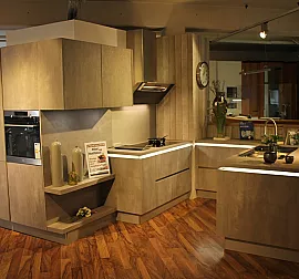 Grifflose Küche in Beton-Optik mit Griffleistenbeleuchtung und hochwertigen Geräten