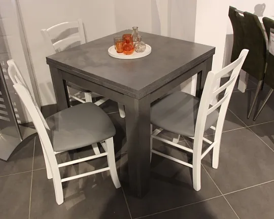 Grauer kleiner Esstisch und weiße Stühle bilden modernen Kontrast - Tischgruppe
