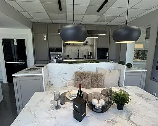 Moderne Landhausküche mit integrierter Sitzmöglichkeit - Lugano Lack Lava, kombiniert mit der Marmor Bianco Arbeitsplatte