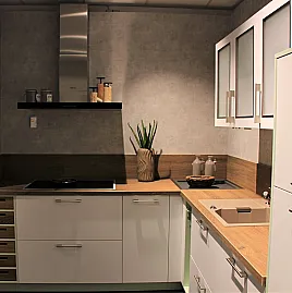 Gemütliche L-Küche mit extra Geräte-Hochschrank für den Kühlschrank in moderner Kombination: Krsitallweiß matt, mit APL in Holzoptik sowie Farbakzenten in Pastellgrün