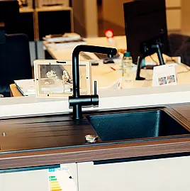 Diese Beton Sand-Küche vereint moderne Schlichtheit und setzt mit der Nussbaum -Arbeitsplatte markante Kontraste