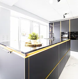 Moderne, grifflose, schwarze Küche, Kanten in Messing Optik inkl. Steinarbeitsfläche und Boschgeräte der Serie 8
