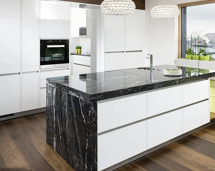 Weiße Küche mit schwarzer Natursteinarbeitsplatte