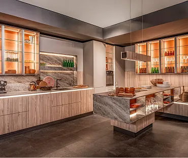 Faceline-Design mit beleuchteten Glasvitrinen und einer Kücheninsel in schwebender Optik